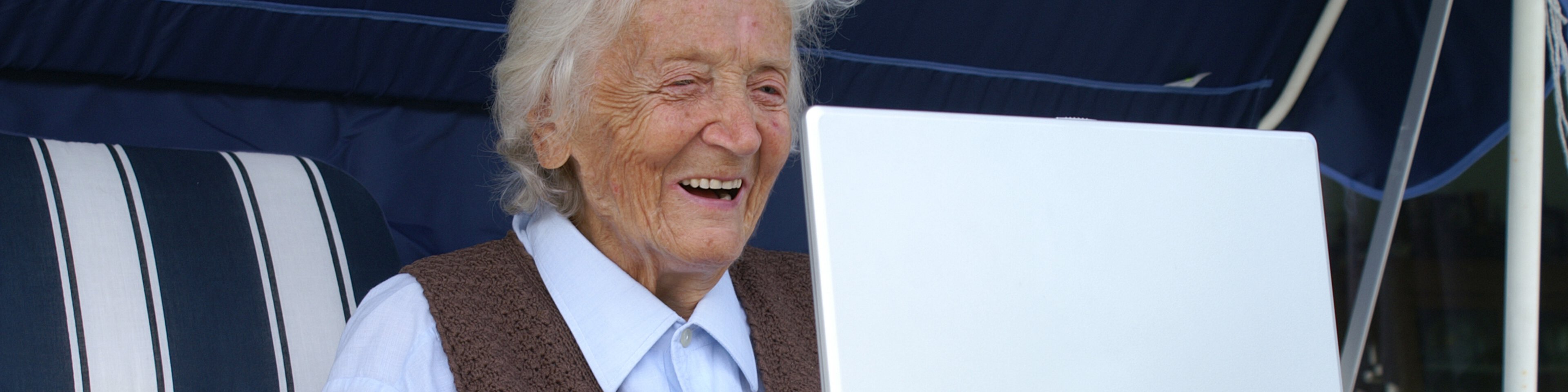 Ältere Dame sitzt lachend vor einem Laptop | © fotolia_meseritsch_innsbruck_25273042